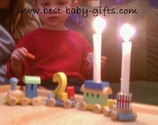 baby boy and a birthday train with two burning candles, also No 2 is on the train