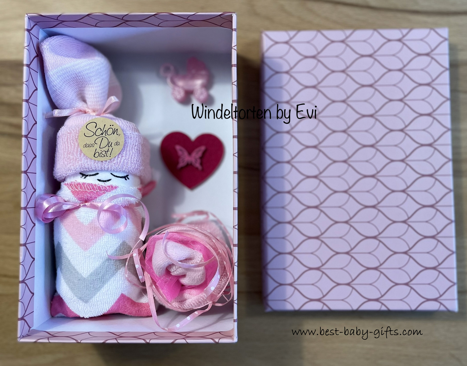 an open pink gift box with a baby diaper inside.