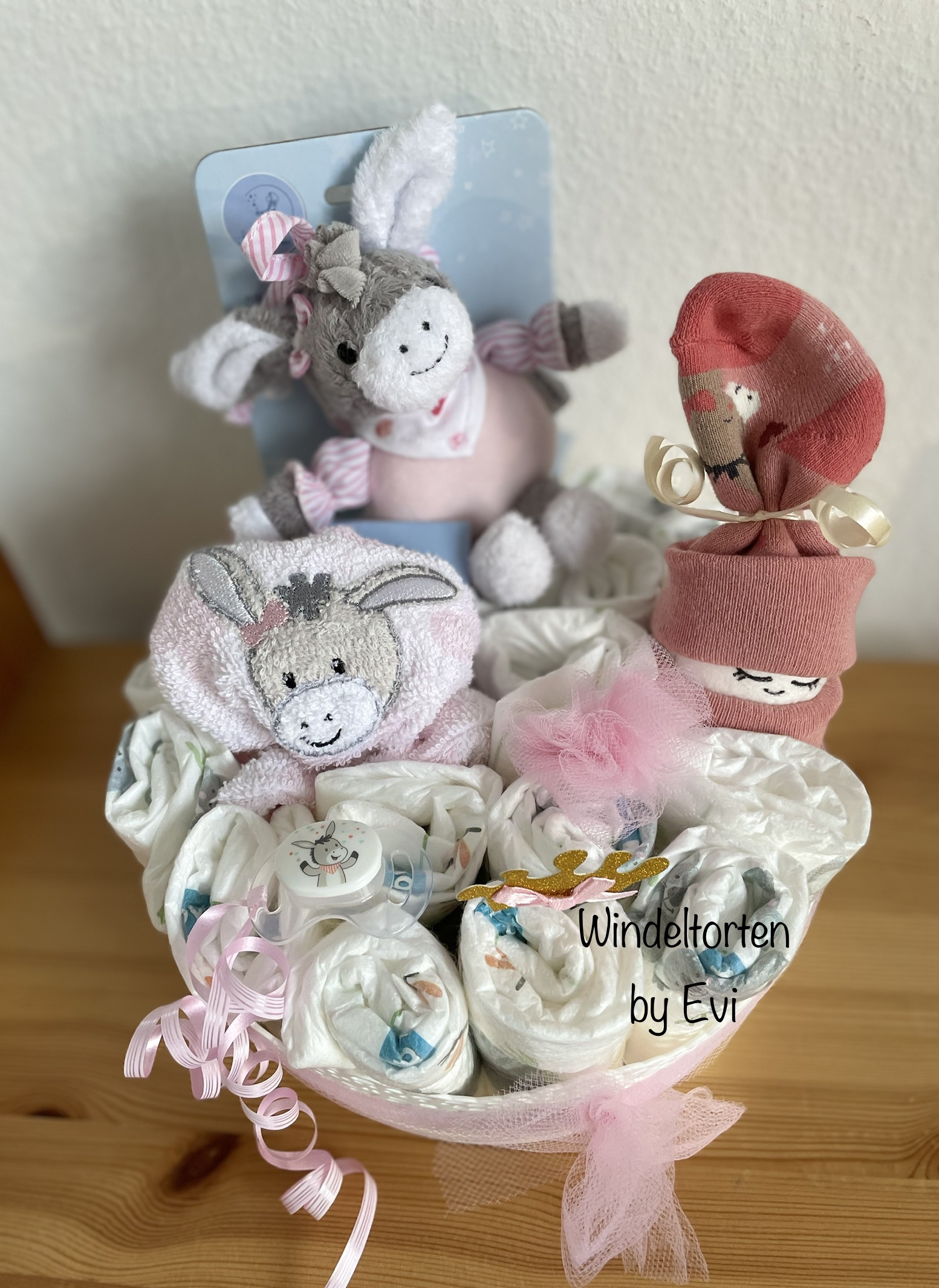 baby girl diaper cake featuring a musical toy donkey