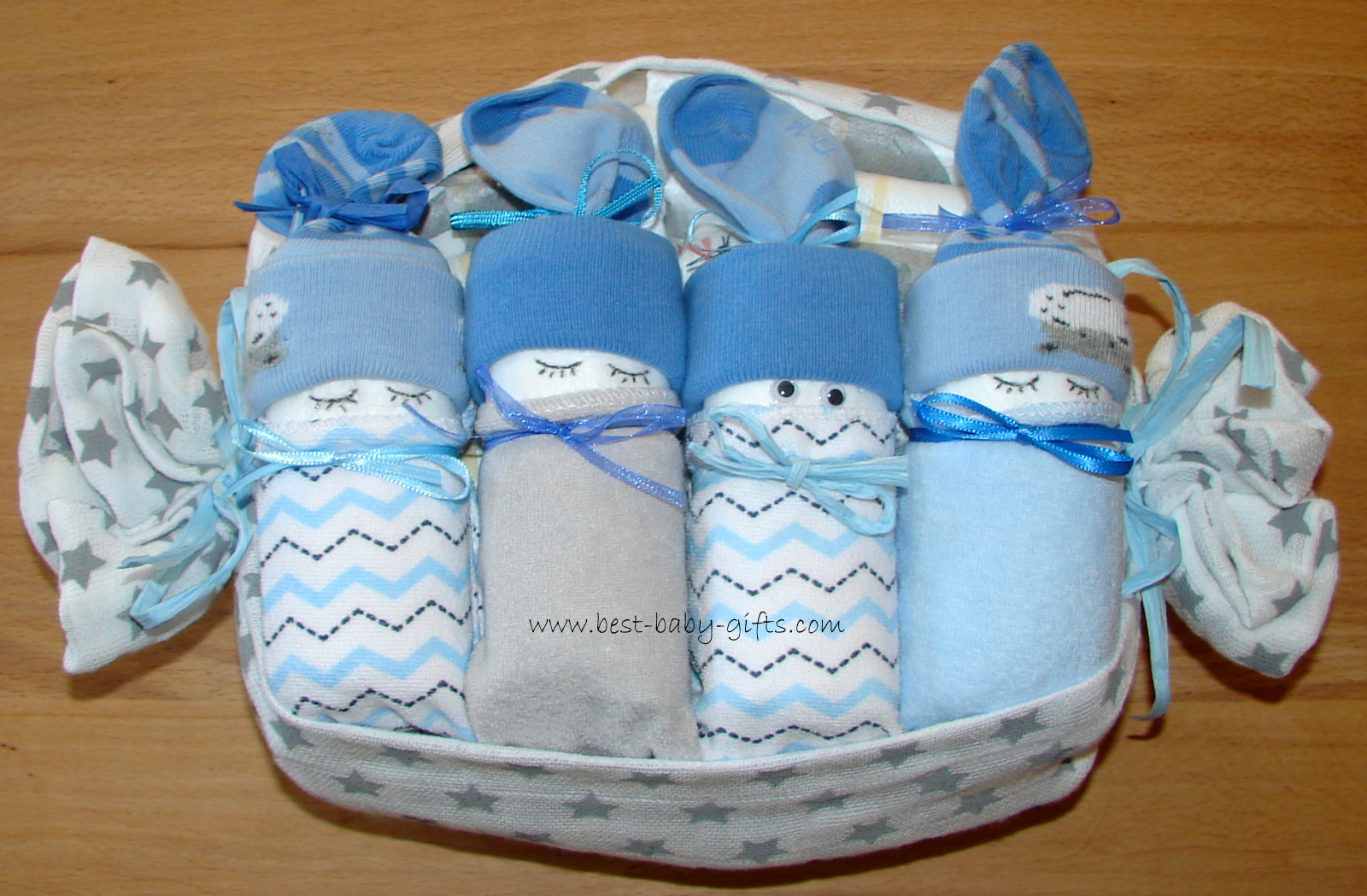 4 blue baby diapers made from organic baby socks and washcloths wrapped in an eco-friendly white burp cloth with gray stars