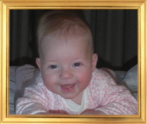 cute smiling baby girl portrait in a golden frame