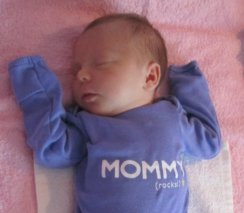 sleeping baby girl wearing a lilac onesie that says 'Mommy rocks'