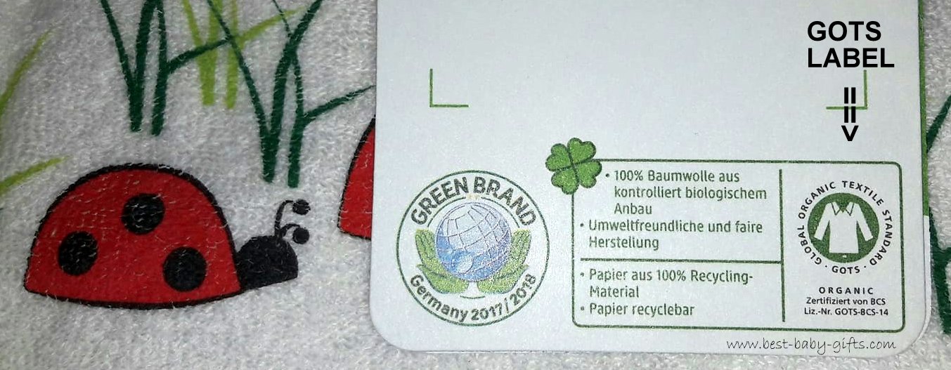 image of a GOTS label attached to a baby bib with a ladybird design