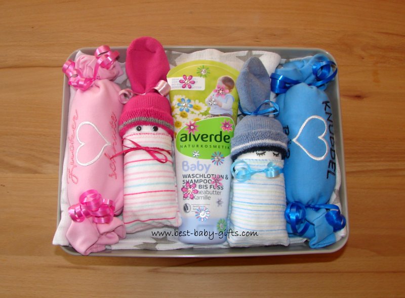 a box full of diapers, 2 pink and blue baby diapers, 2 pink and blue onesies and some baby shower gel